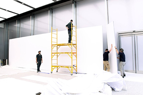 Employés du MBA avec des échafaudages pendant le montage de l'exposition avec des cloisons Mila-wall